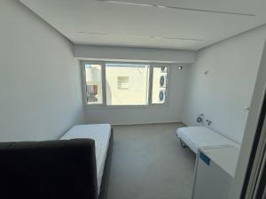 une petite chambre avec deux lits et une fenêtre dans l'établissement Dashaj Rooms 302, à Ksamil