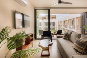 a living room with a couch and a table at Itzel Samsara Dream Penthouse in Tulum