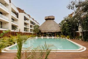 a swimming pool in front of a building at Itzel Samsara Dream Penthouse in Tulum