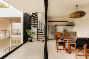 a kitchen and dining room with a spiral staircase in a house at Itzel Samsara Dream Penthouse in Tulum