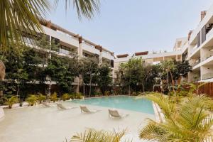 a swimming pool in front of a building at Itzel Samsara Dream Penthouse in Tulum