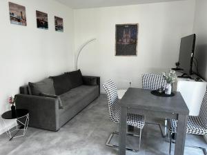 a living room with a couch and a table at Ferienwohnung - Haus mit Faßsauna - Nähe Fulda in Großenlüder