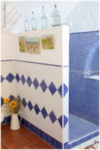 a bathroom with a blue and white tiled wall at Casa Cueva Alhama in Graena