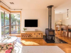 a living room with a fireplace and a flat screen tv at Stylish 3BR Walk to Town in Trentham