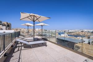 a patio with chairs and umbrellas on a roof at Old Theatre Suites - Capri in Valletta