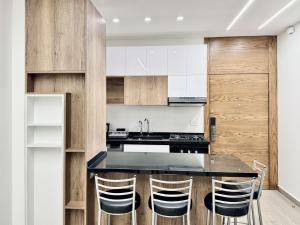 a kitchen with a black counter and wooden cabinets at Eden - 2-BR in Tilal Aassal in Fārayyā