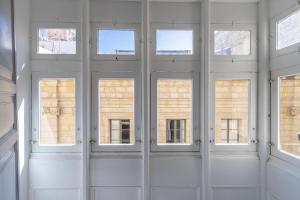 a group of windows in a room with white walls at Old Theatre Suites - Capri in Valletta +8 photos