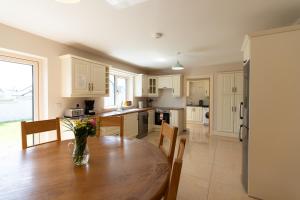 a kitchen with a wooden table with a vase of flowers on it at No 59 - Luxury Townhouse Dingle in Dingle