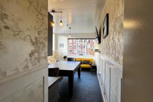 a living room with a table and a yellow couch at Central Sheffield 3-Bed Apt Sleeps 6 with Parking in Sheffield