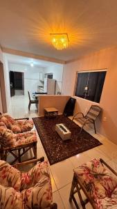 a living room with couches and a living room with a table at Hospedagem Vô João in Gravatal +28 photos
