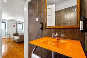a bathroom with a yellow sink and a mirror at Casa do Patio by Shiadu in Lisbon +35 photos