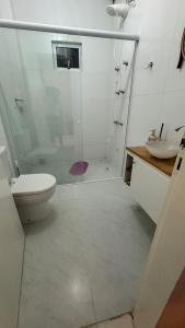a bathroom with a shower and a toilet and a sink at Hospedagem Vô João in Gravatal