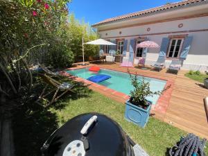 a backyard with a swimming pool and a house at Typical Toulouse house completely renovated in Launaguet