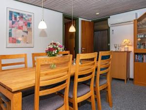 a dining room with a wooden table and chairs at 6 person holiday home in Ebeltoft-By Traum in Ebeltoft