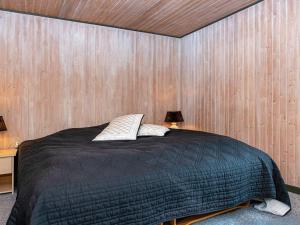 a bedroom with a bed with a wooden wall at 6 person holiday home in Ebeltoft-By Traum in Ebeltoft +11 photos
