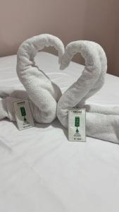 two towels sitting on a bed with two price tags at Hospedagem Vô João in Gravatal +28 photos