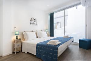 ein Schlafzimmer mit einem großen Bett und einem großen Fenster in der Unterkunft Casa da Vila in Faro