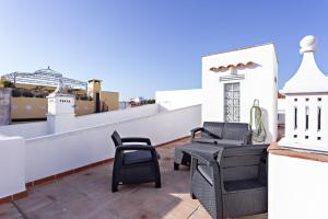 ein Balkon mit Stühlen und Tischen auf einem Dach in der Unterkunft Casa da Vila in Faro