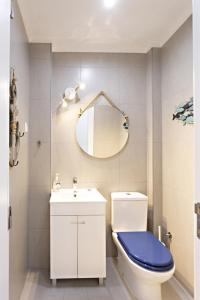 ein Badezimmer mit Toilette, Waschbecken und Spiegel in der Unterkunft Casa da Vila in Faro + 17 Fotos