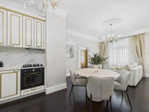 a kitchen and dining room with a table and chairs at Vāgnera Rezidence in Rīga +18 photos