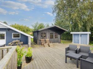 a deck with a cabin with a table and chairs at Spacious Retreat in Skovmose-By Traum in Neder Lysabild