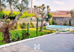 a backyard with a swimming pool and trees at MyStay - Casa Aguarela in São Romão