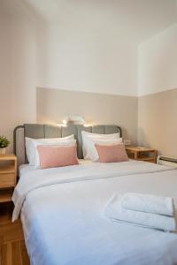 a large white bed with two towels on it at Old Town Church Bells in Kotor