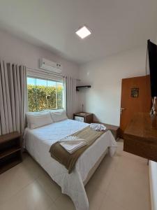 a bedroom with a large bed and a window at POUSADA RECANTO DAS VERTENTES in Capitólio +47 photos