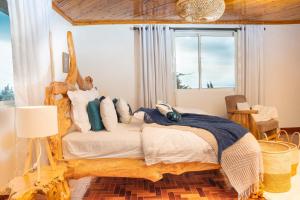 a bedroom with a wooden bed in a room with a window at Hilltop Lakeview in Munyu +16 photos
