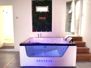 a bath tub in a room with a sign that reads love at Room Jacuzzi in Aubervilliers