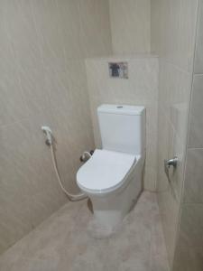 La salle de bains est pourvue d'une douche et de toilettes blanches. dans l'établissement Hewune Uptown Stay, à Kandy