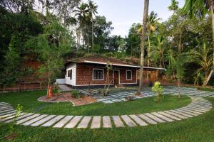 a small house with a garden in front of it at Anoop's Lake View Cottage -2BHK in Munroe Island