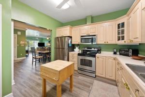 a kitchen with green walls and wooden cabinets at Ruthie's Roost villa by Peace Vacations in Georgetown