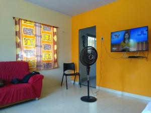 een woonkamer met een rode bank en een flatscreen-tv bij Casa aconchegante em cotijuba in Ilha Paquetá-Açu +30 foto's
