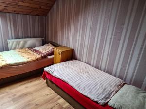 a bedroom with two beds and a wooden floor at Willa Mortęgi in Lubawa
