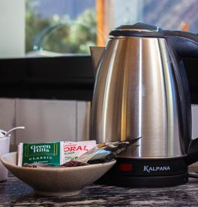 - une bouilloire et un bol de nourriture sur un comptoir dans l'établissement Los Olivos Purmamarca - Cabañas Boutique, à Purmamarca