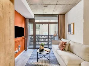 una sala de estar con un sofá y una mesa en Stylish studio with Pool Access, en Ciudad del Cabo