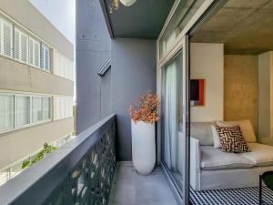 Un balcón con un sofá y un jarrón encima. en Stylish studio with Pool Access, en Ciudad del Cabo