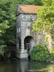 an old building with a bridge over a river at Chambre Solognote in Saint-Pryvé-Saint-Mesmin