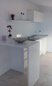a white kitchen with a counter with a sink at Apartment Bocca in Neum +25 photos