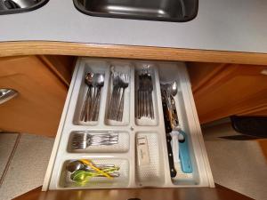 a tray with utensils in a drawer in a kitchen at Lazy Days Caravan in Berlin