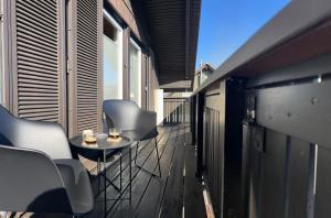 a balcony with chairs and a small table on a building at Schwarzwald Apartments III in Lenzkirch