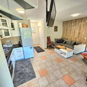 a kitchen and a living room with a couch at Vikendica na Sani Datea in Sanski most +14 photos