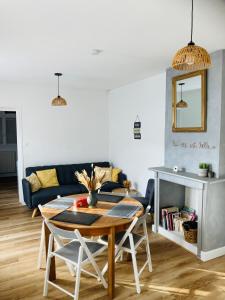un soggiorno con un tavolo e un divano di Maison avec 2 chambres et jardin a Montfort-le-Gesnois