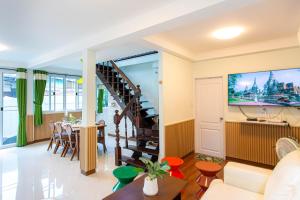 a living room with a tv and a staircase at Friend House BKK in Bangkok