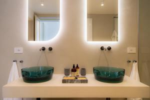 a bathroom with two green sinks and a mirror at Palazzo Console in Lecce