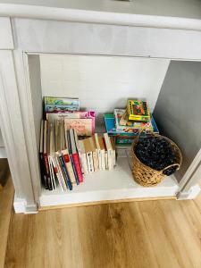 una libreria piena di libri e un cesto di Maison avec 2 chambres et jardin a Montfort-le-Gesnois Altre 12 foto