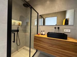 a bathroom with a sink and a glass shower at 1 Ch. Luxe Apt｜Cœur de Juan-les-Pins｜Plage à 50m in Juan-les-Pins +29 photos