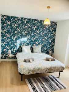una camera da letto con un letto con carta da parati floreale di Maison avec 2 chambres et jardin a Montfort-le-Gesnois