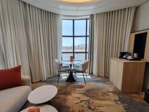 ハーイルにあるAyas Hotelのテーブルと椅子と大きな窓のあるリビングルーム +61枚の写真